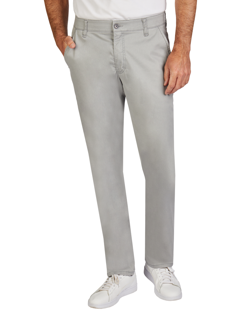 Bild zeigt einen Mann in hellgrauen Jeans, die gerade geschnitten sind. Er trägt ein weißes T-Shirt und weiße Turnschuhe. Seine rechte Hand steckt in der Hosentasche, die linke ruht an der Seite. Die Jeans haben Gürtelschlaufen und eine Knopfleiste.