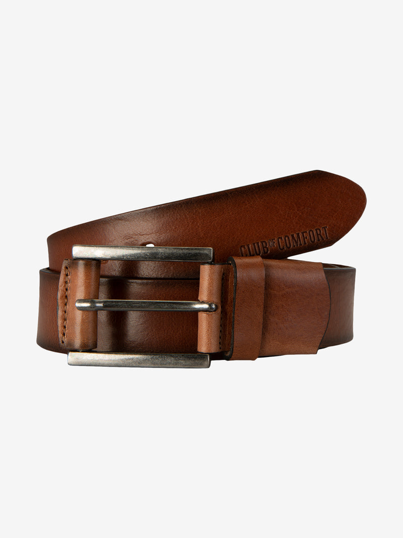Ein brauner Leder Gürtel mit silberner Schnalle, liegend auf einer weißen Oberfläche. Der Gürtel ist teilweise eingerollt, mit dem Text "CLUB & COMFORT" auf der Innenseite sichtbar.