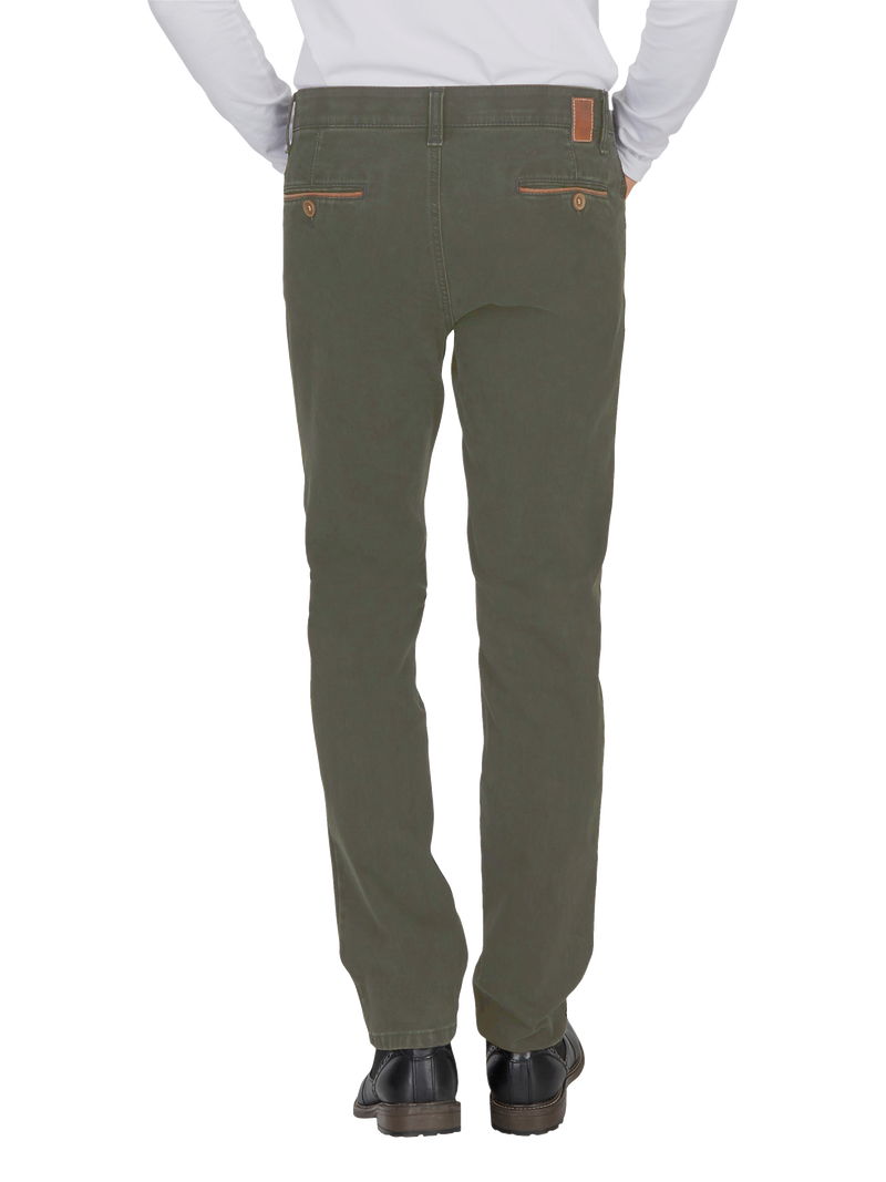 Blick auf die Rückseite eines Mannes, der eine weiße Hemd und grüne Jeans trägt. Die Jeans haben zwei Taschen mit Knopfdachrand, einen braunen Lederetikett am Bund und eine schmale Passform.