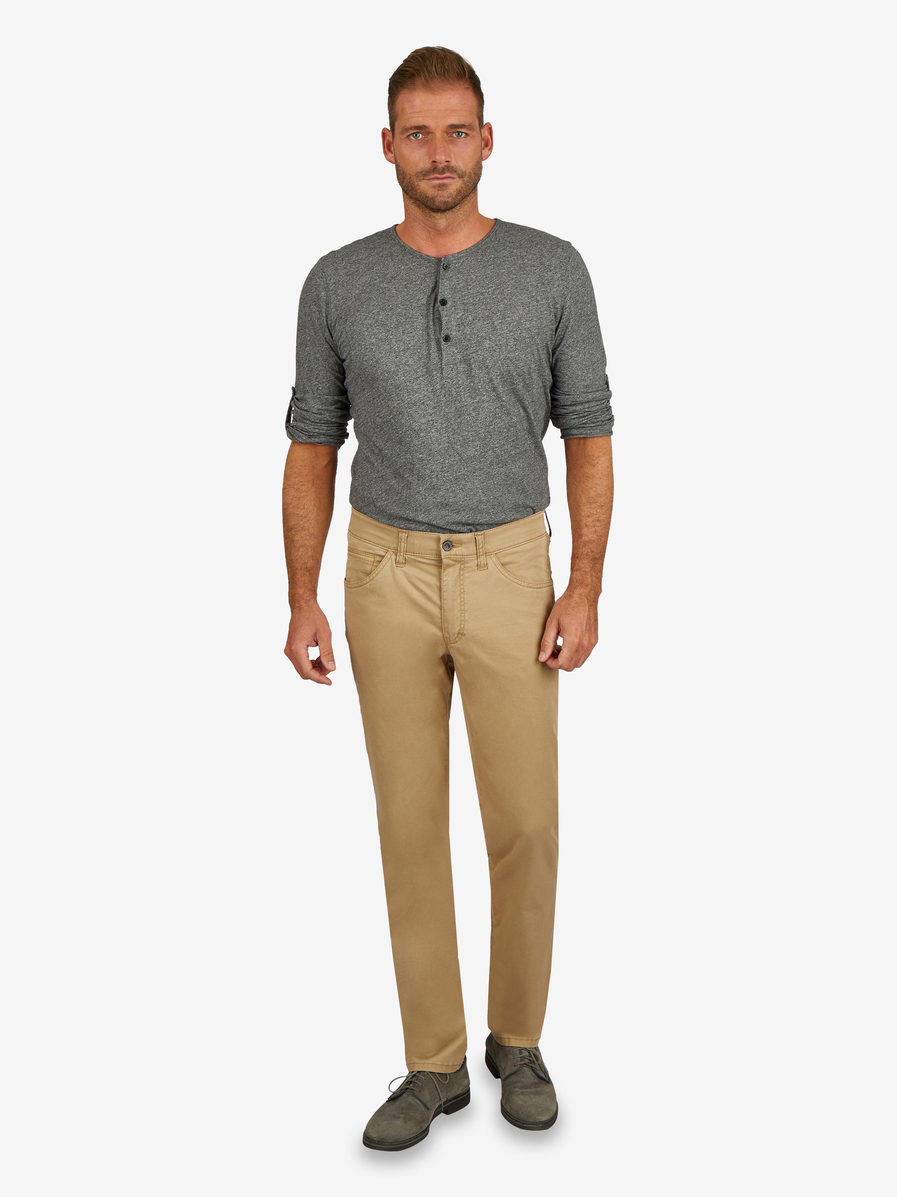 Mann trägt beige MARVIN 7708 Hose mit bequemem Comfortbund, Hemdenstopper, modifizierte 5-Pocket-Form, aus leichtem Baumwoll-High-Stretch, normaler Leibhöhe und schmalem Bein, kombiniert mit grauem Longsleeve.