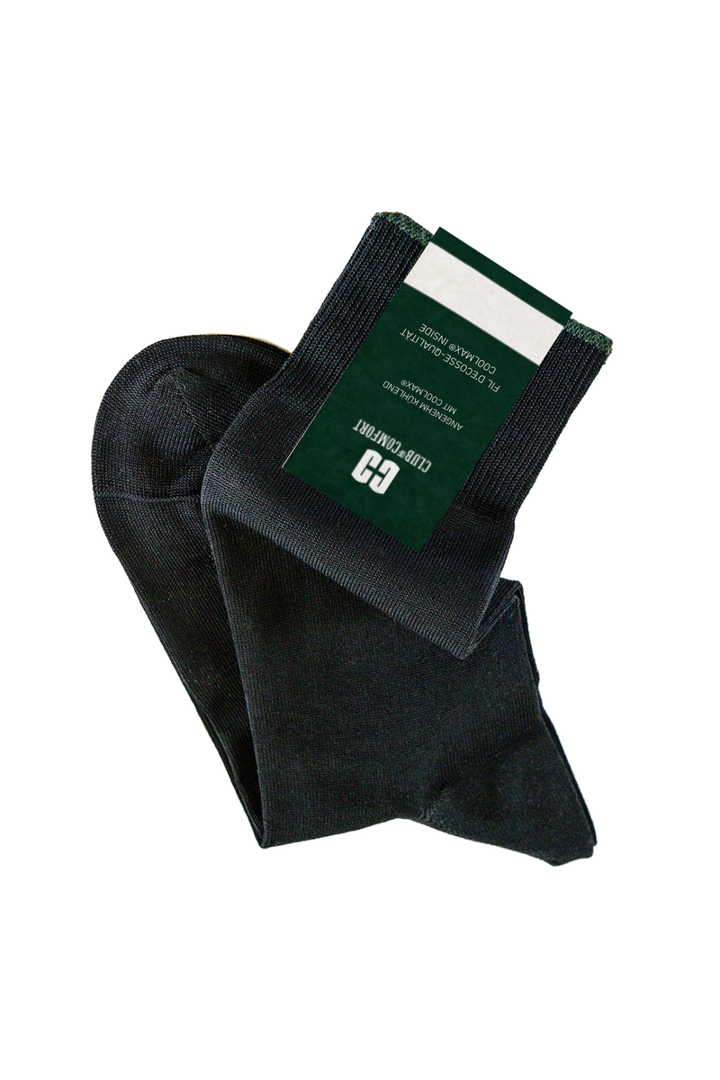 Das Bild zeigt ein Paar schwarze Golf- oder Tennissocken mit einem Greenkeeper- oder Club-Logo auf einem weißen und grünen Etikett, das an einem Socken befestigt ist.