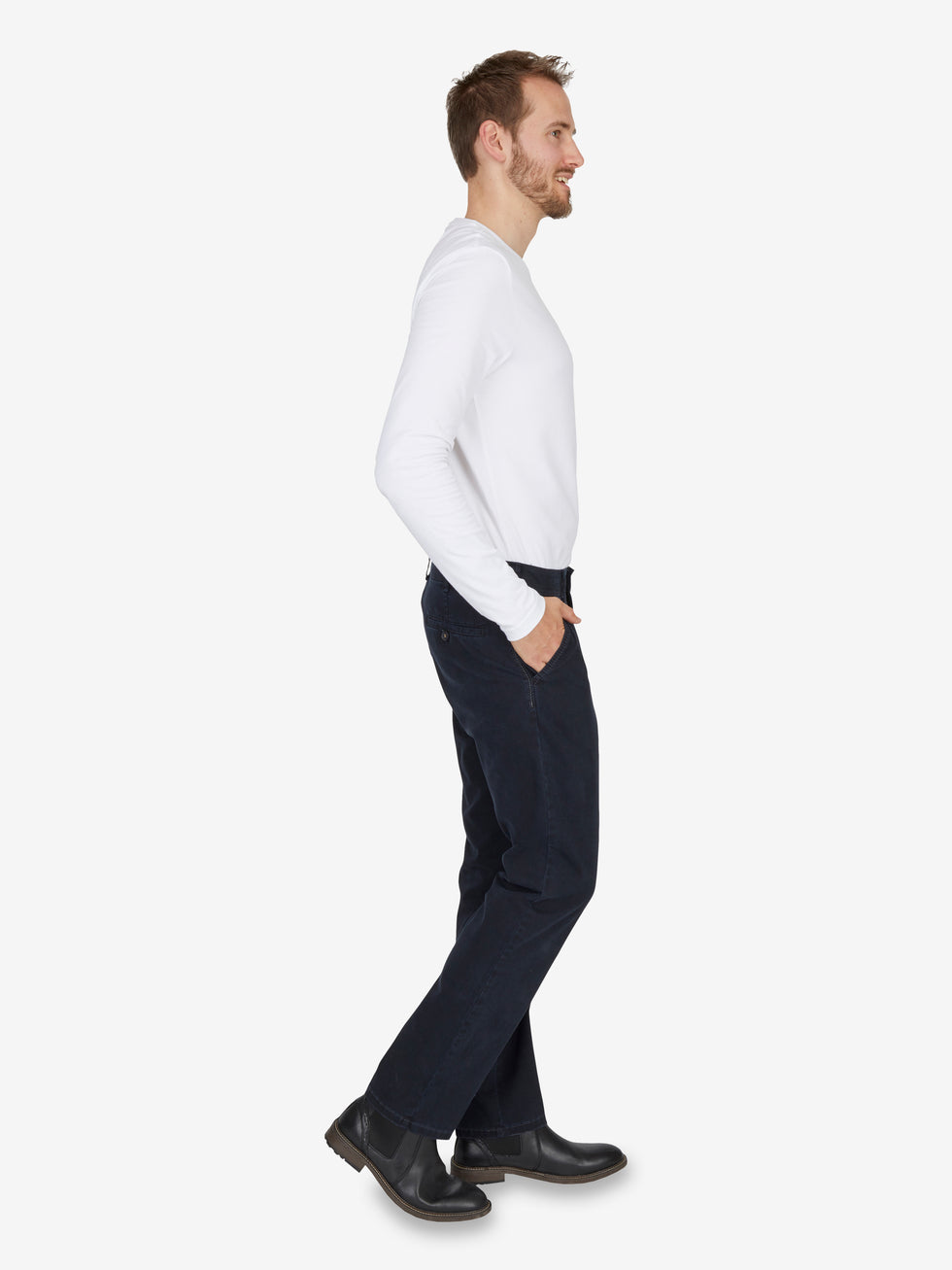 Seitenansicht eines Mannes, der eine dunkelblaue Denver 7819 Flat Front-Hose von Club of Comfort trägt, mit elastischem Komfortbund, Hemdenstopper, aus blauem Baumwoll-Gabardine mit High Stretch, gerade Passform, kombiniert mit weißem Pullover und schwarzen Schuhen auf weißem Hintergrund.
