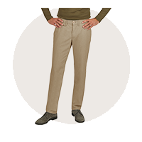 Ein Mann trägt beige Stoffhose, die an der Taille sitzt, sowie einen dunkelgrünen Pullover.